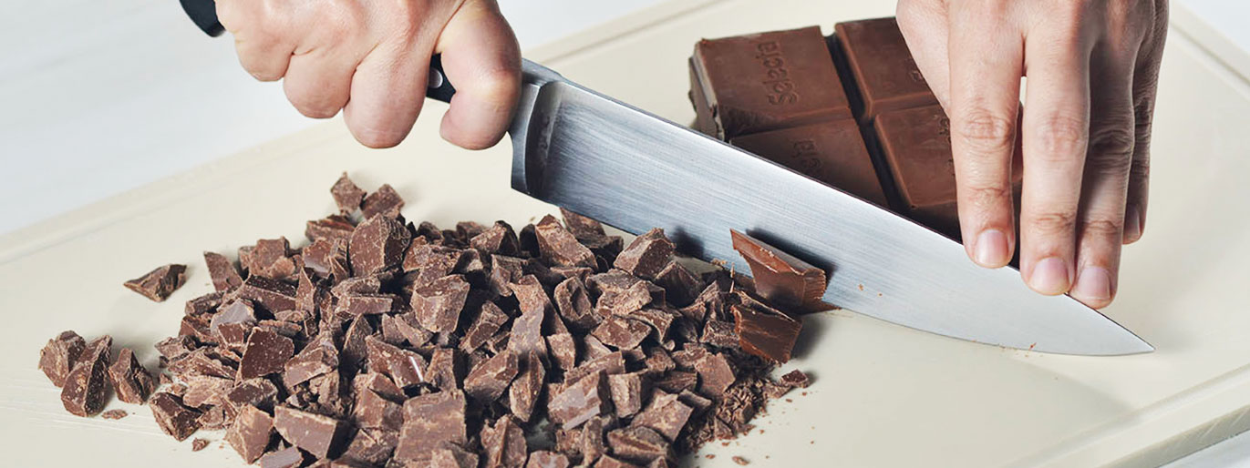 barra de chocolate sendo cortada com uma faca